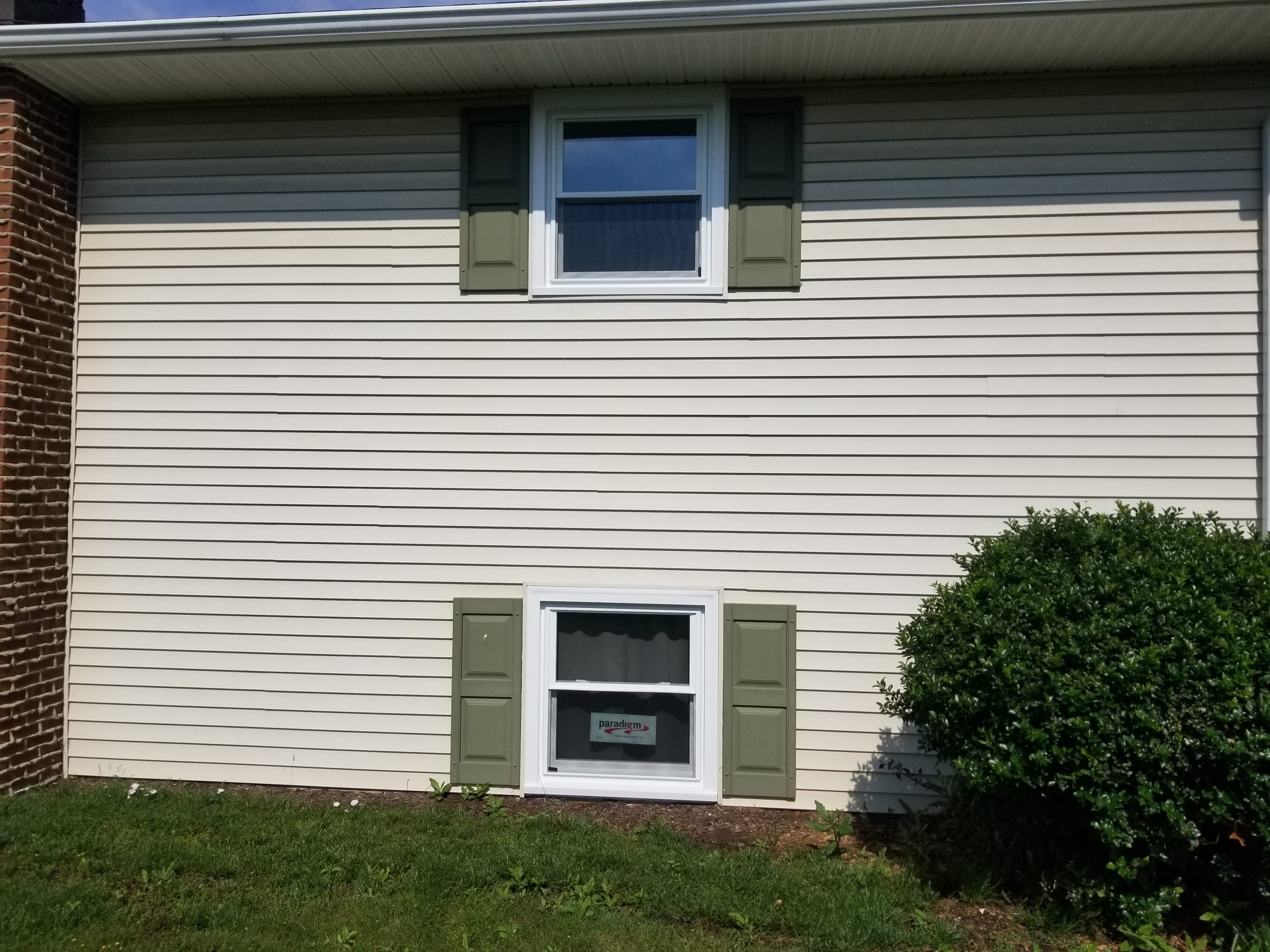 new white windows with green shutters on cream siding